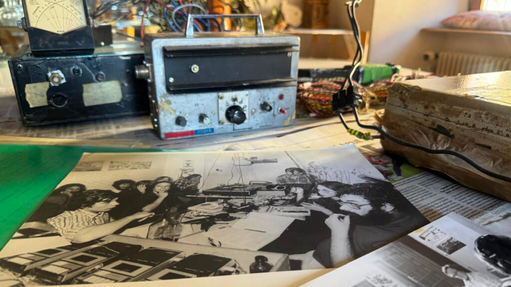 Sur une table, les militants ont installé des anciens émetteurs et récepteurs radios et une photo d'archives.