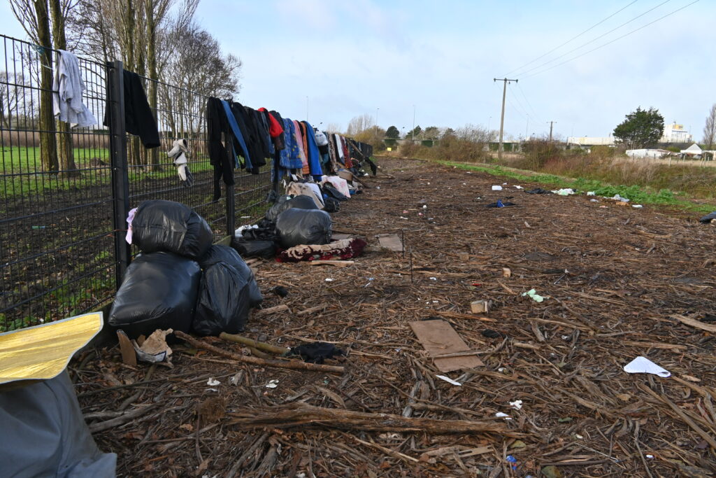 sac poubelle et des vêtements trainant dans la nature